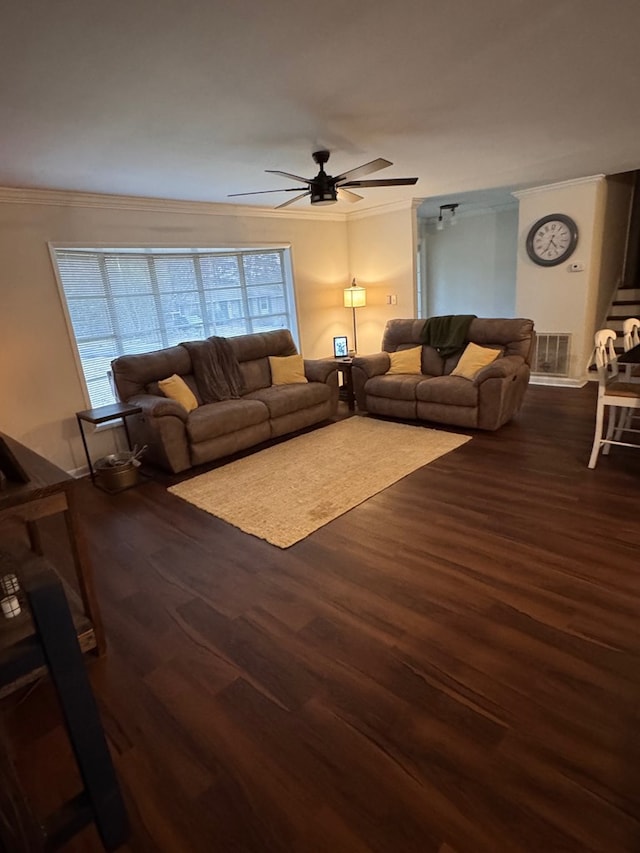 unfurnished living room featuring dark wood-type flooring, ornamental molding, and ceiling fan