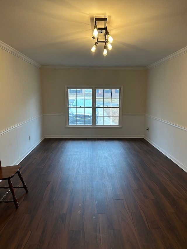 unfurnished room with dark hardwood / wood-style flooring, crown molding, and a notable chandelier