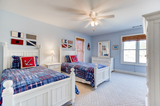 bedroom with light carpet, visible vents, a ceiling fan, and baseboards