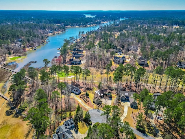 birds eye view of property with a view of trees and a water view