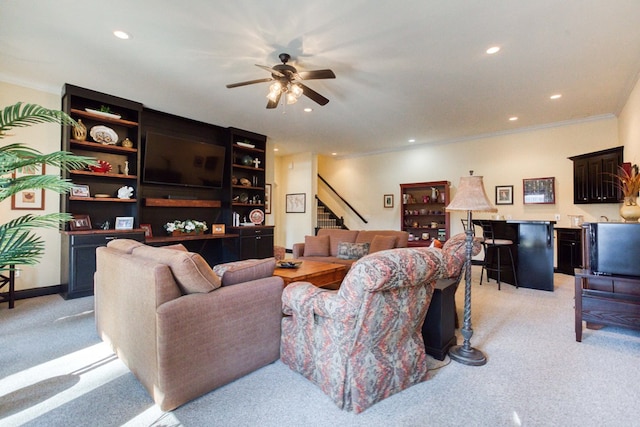 living area featuring stairway, a ceiling fan, recessed lighting, ornamental molding, and light carpet