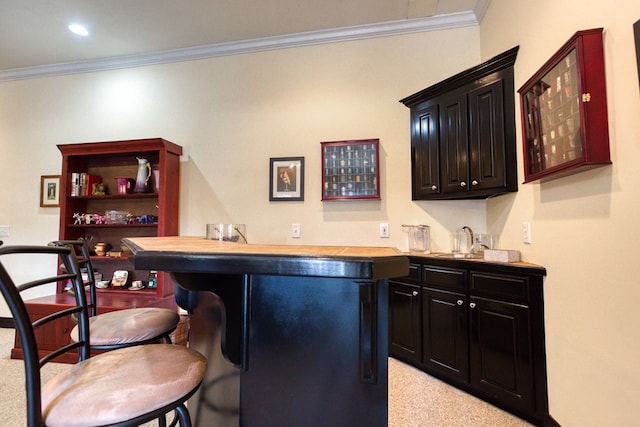 bar with indoor wet bar, light carpet, and crown molding