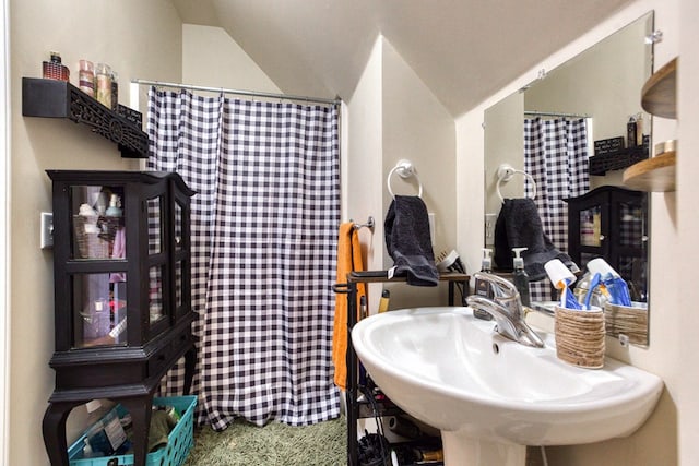 full bath featuring a sink, lofted ceiling, and a shower with curtain