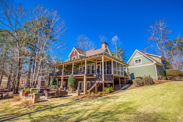 back of property featuring a patio, a sunroom, a chimney, stairs, and a lawn