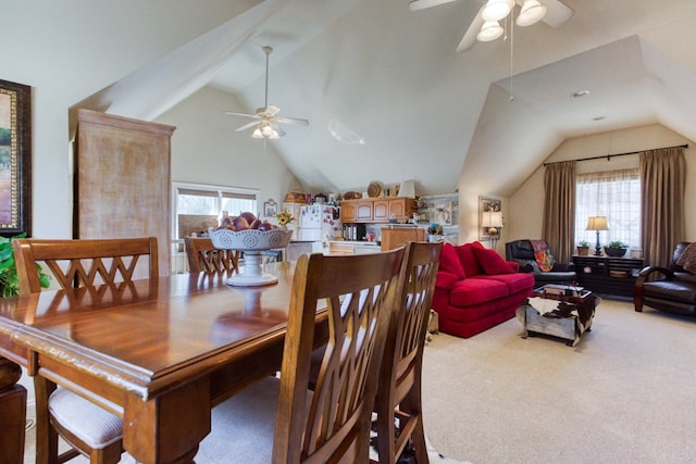 carpeted dining space with a ceiling fan and vaulted ceiling