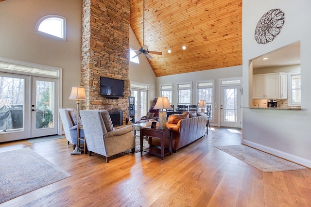 living area featuring light wood finished floors, french doors, and a fireplace