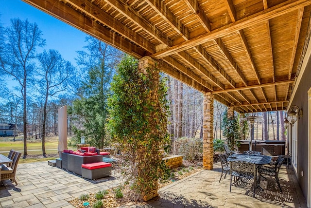 view of patio / terrace featuring outdoor dining space, an outdoor hangout area, and a hot tub