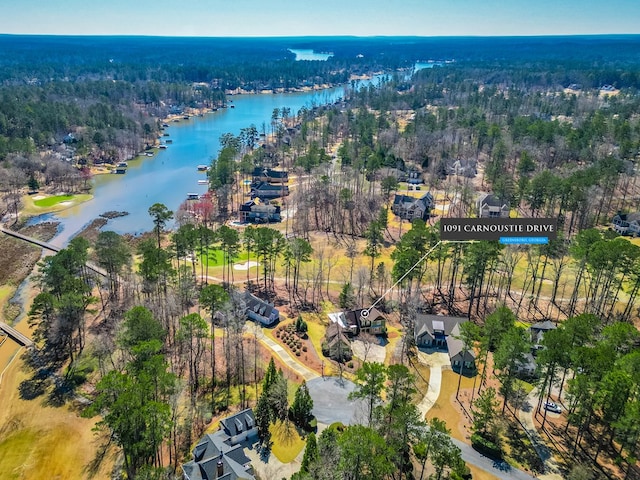 drone / aerial view featuring a wooded view and a water view