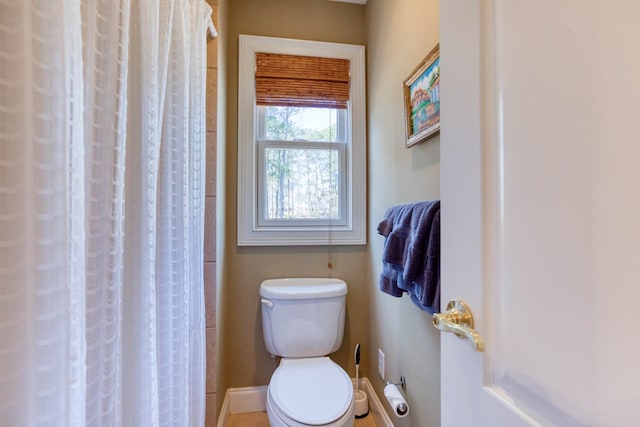 full bathroom with a shower with curtain, toilet, and baseboards