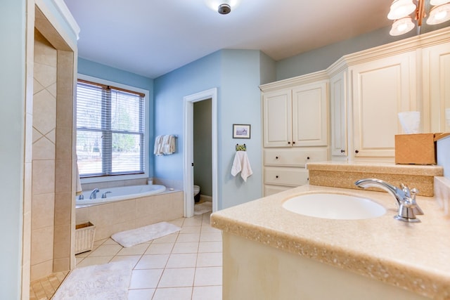 bathroom featuring vanity, a garden tub, toilet, tile patterned floors, and a notable chandelier