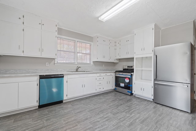 kitchen featuring a textured ceiling, sink, white cabinetry, and stainless steel appliances