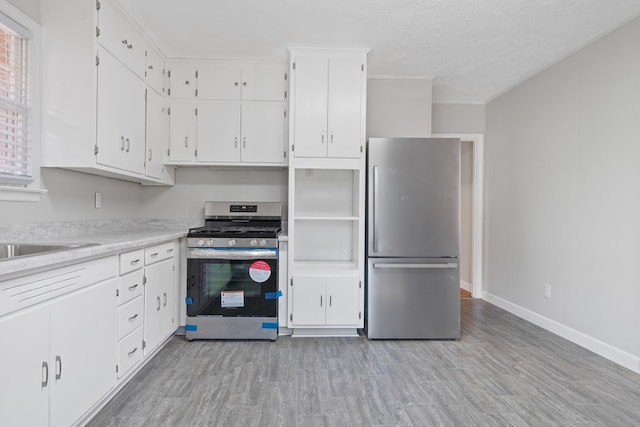 kitchen featuring a textured ceiling, white cabinetry, and stainless steel appliances