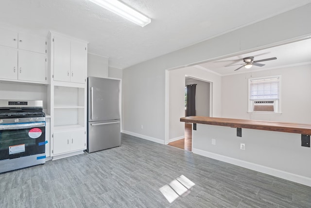 kitchen featuring ceiling fan, white cabinets, stainless steel appliances, and a textured ceiling