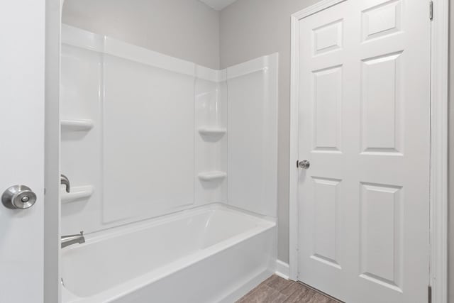 bathroom featuring shower / bathing tub combination and hardwood / wood-style flooring