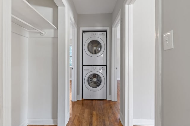 laundry area featuring dark hardwood / wood-style flooring and stacked washing maching and dryer