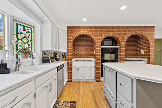 220 Oconnor Dr, Milledgeville, GA 31061 - kitchen with a sink, stainless steel dishwasher, white cabinets, light countertops, and ornamental molding
