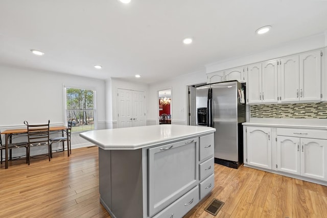 220 Oconnor Dr, Milledgeville, GA 31061 - kitchen with stainless steel fridge with ice dispenser, white cabinetry, light countertops, a center island, and light wood-style flooring