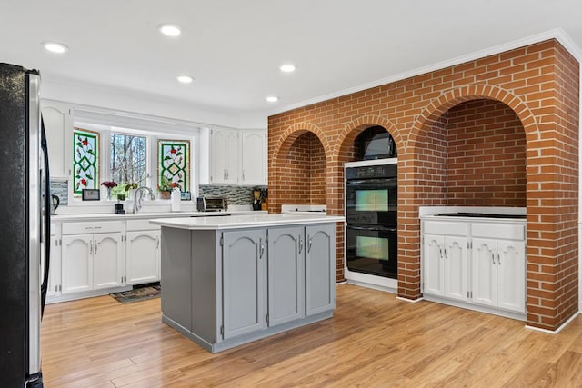 220 Oconnor Dr, Milledgeville, GA 31061 - kitchen featuring freestanding refrigerator, white cabinetry, crown molding, light countertops, and light wood-type flooring