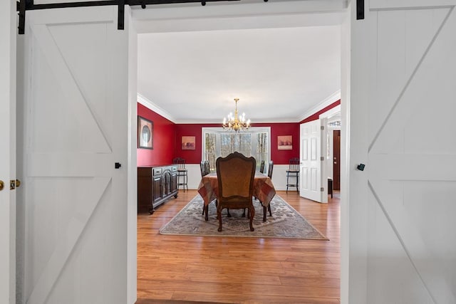 220 Oconnor Dr, Milledgeville, GA 31061 - dining room featuring a barn door, light wood finished floors, crown molding, and a chandelier