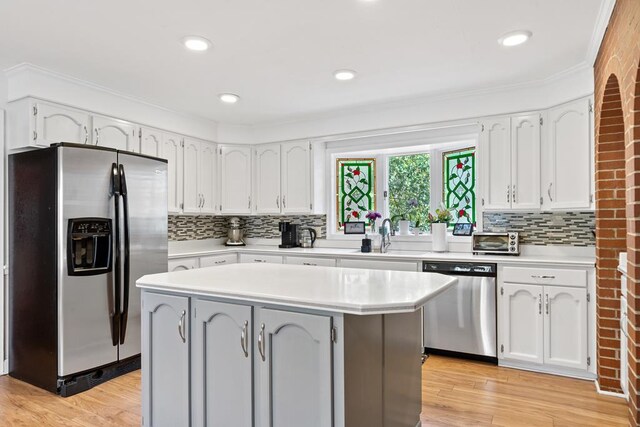 220 Oconnor Dr, Milledgeville, GA 31061 - kitchen with appliances with stainless steel finishes, a sink, white cabinetry, backsplash, and ornamental molding
