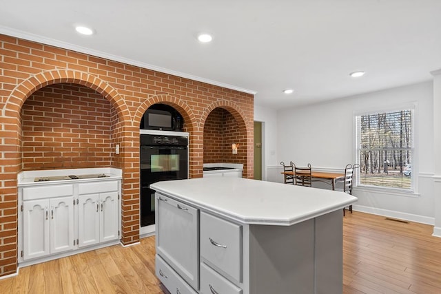 220 Oconnor Dr, Milledgeville, GA 31061 - kitchen with light wood-style floors, a kitchen island, light countertops, white cabinetry, and recessed lighting