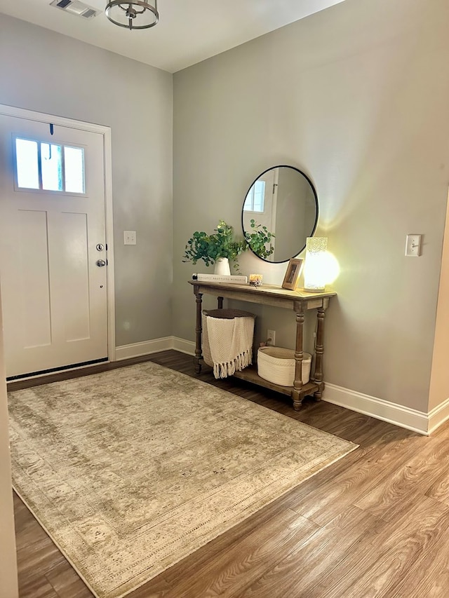 entryway featuring visible vents, baseboards, and wood finished floors