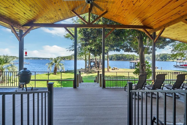 deck with a water view, a gazebo, and a yard