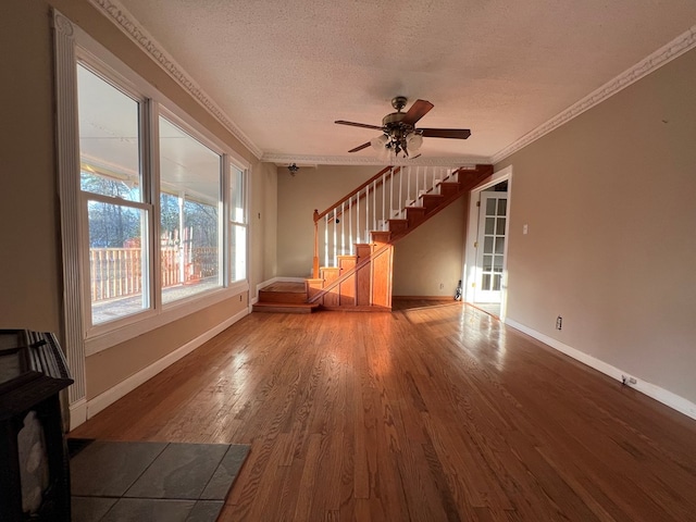 unfurnished living room with ornamental molding, hardwood / wood-style floors, ceiling fan, and a textured ceiling