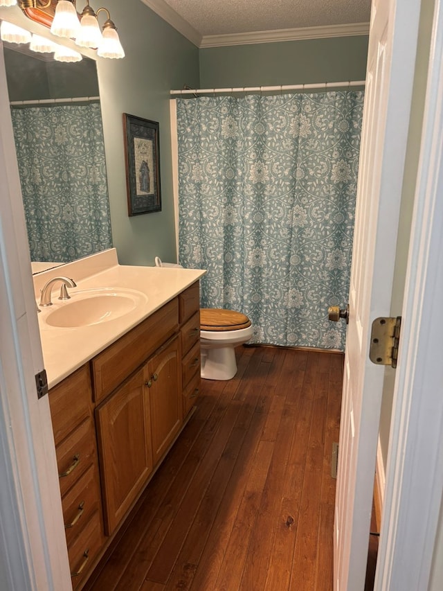 full bath featuring a textured ceiling, wood finished floors, vanity, and crown molding