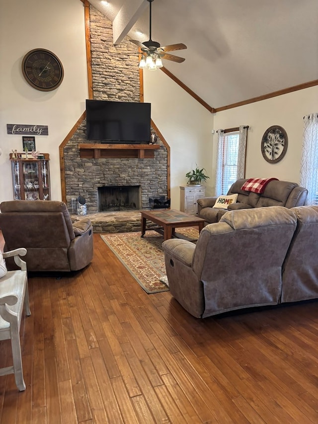 living room with a ceiling fan, high vaulted ceiling, wood finished floors, and a stone fireplace