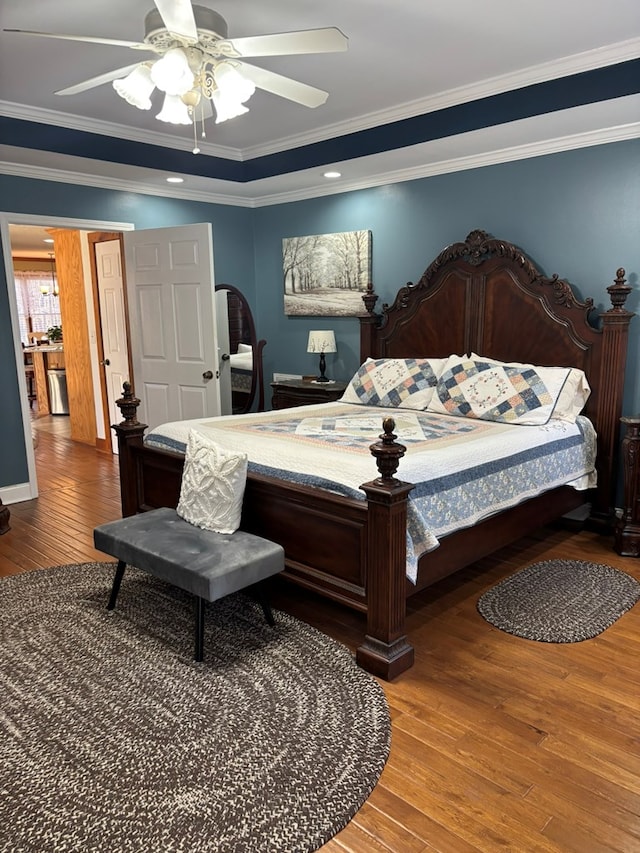 bedroom with ceiling fan, wood finished floors, and crown molding