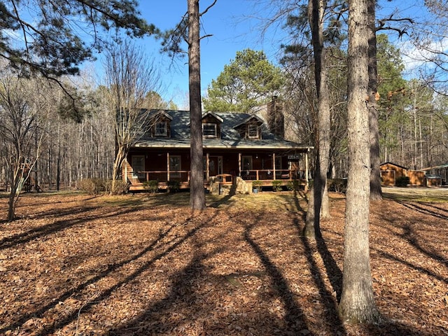 view of front facade with a chimney and a porch