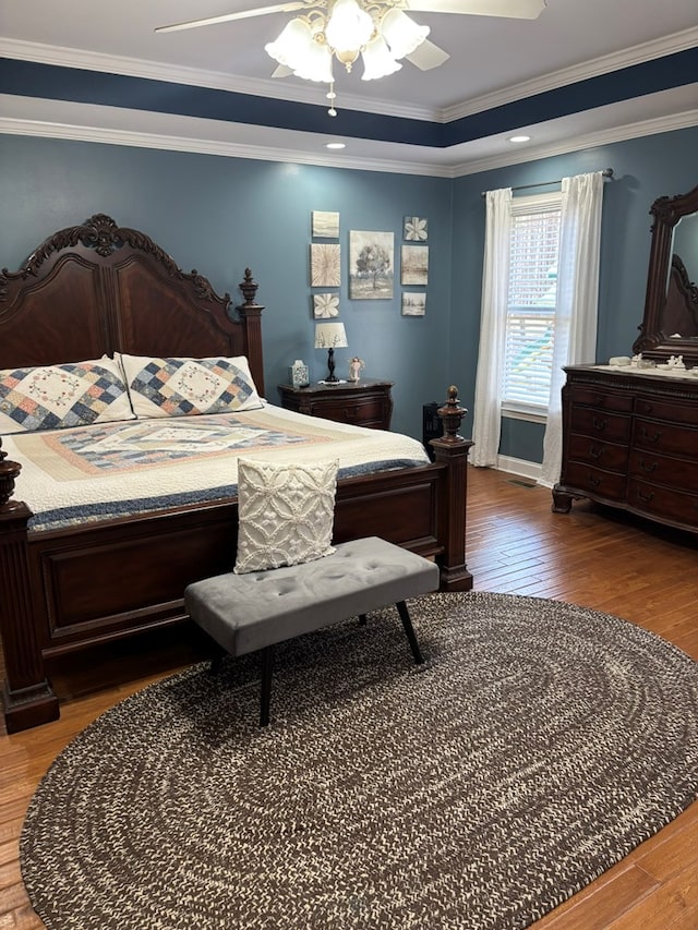 bedroom featuring ornamental molding, a ceiling fan, and wood finished floors