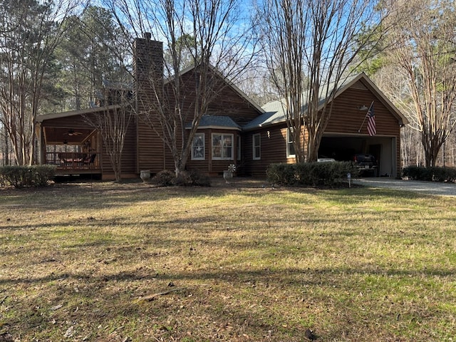 view of front facade featuring an attached garage, a chimney, and a front lawn