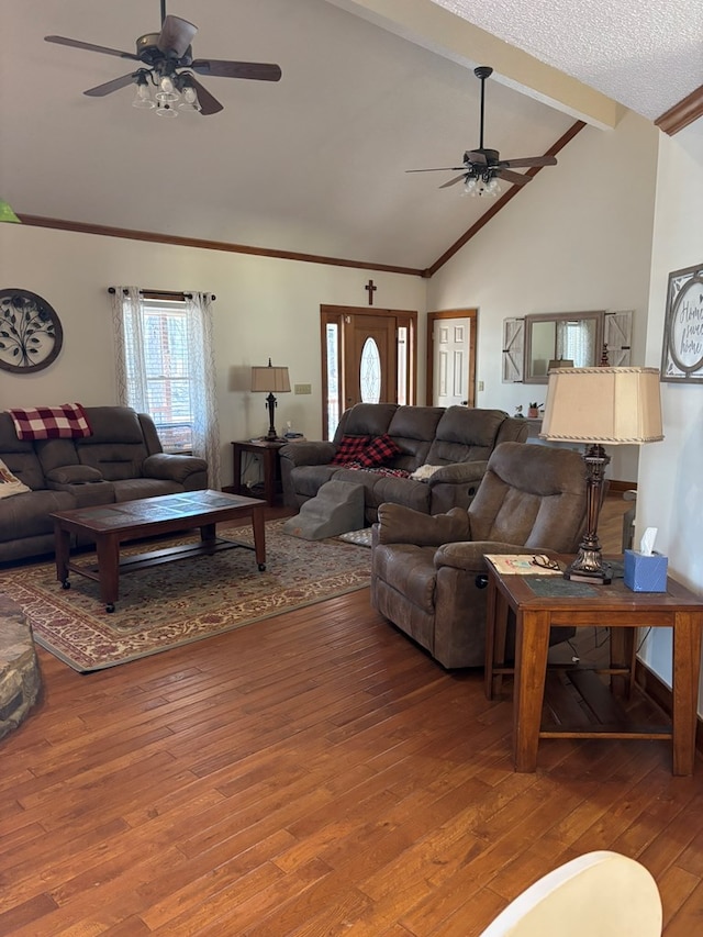 living area with lofted ceiling with beams, ceiling fan, crown molding, and wood finished floors