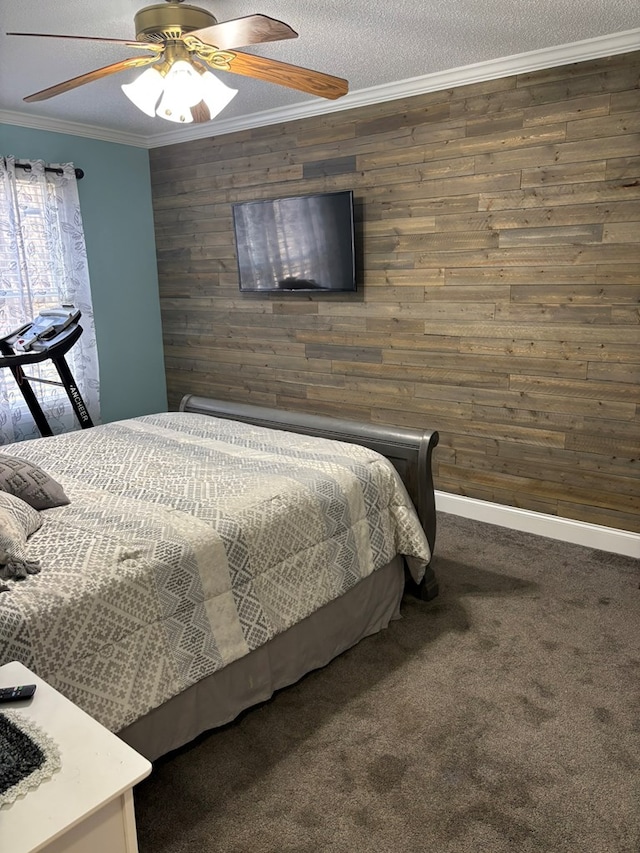 bedroom with dark carpet, ornamental molding, a ceiling fan, a textured ceiling, and wooden walls