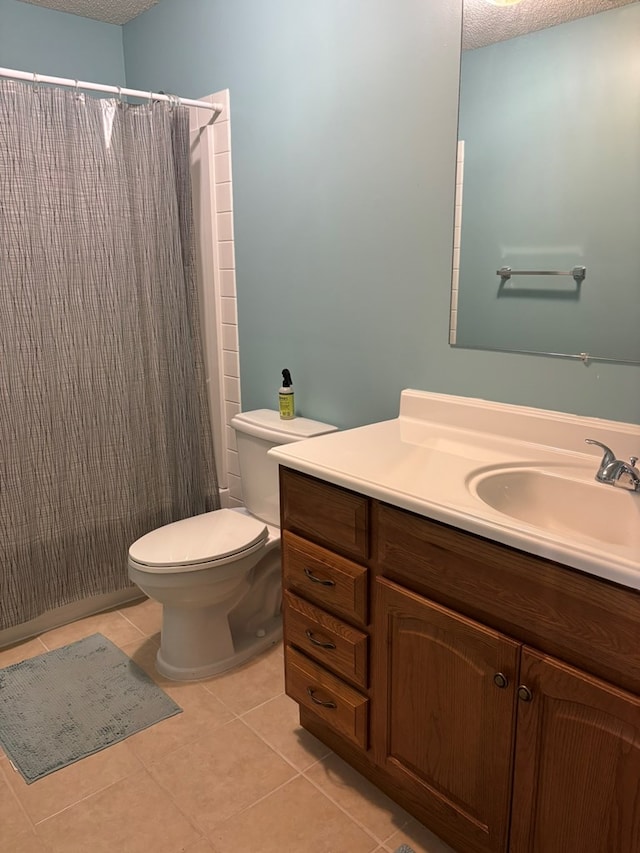 full bath with a shower with shower curtain, toilet, vanity, a textured ceiling, and tile patterned floors