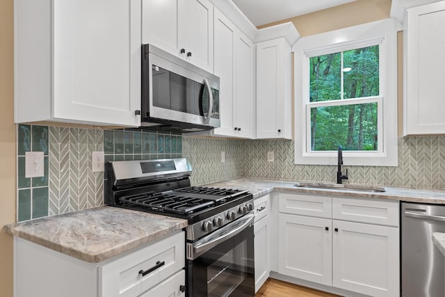 172 Southshore Rd, Eatonton, GA 31024 - kitchen featuring stainless steel appliances, white cabinets, tasteful backsplash, and light stone countertops
