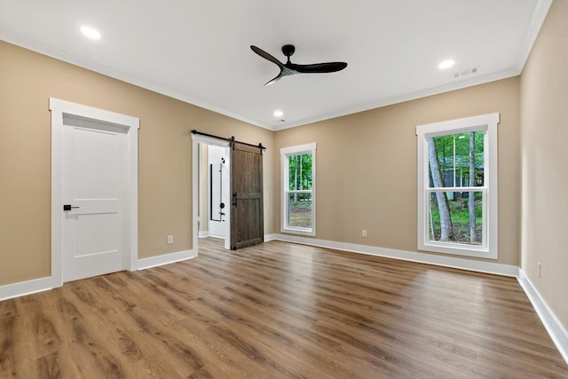 172 Southshore Rd, Eatonton, GA 31024 - unfurnished bedroom featuring multiple windows, ornamental molding, a barn door, wood finished floors, and recessed lighting