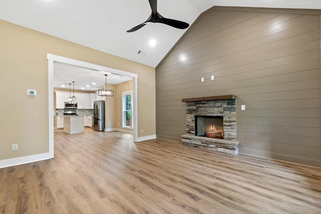 172 Southshore Rd, Eatonton, GA 31024 - unfurnished living room with light wood finished floors, a ceiling fan, recessed lighting, a fireplace, and wood walls