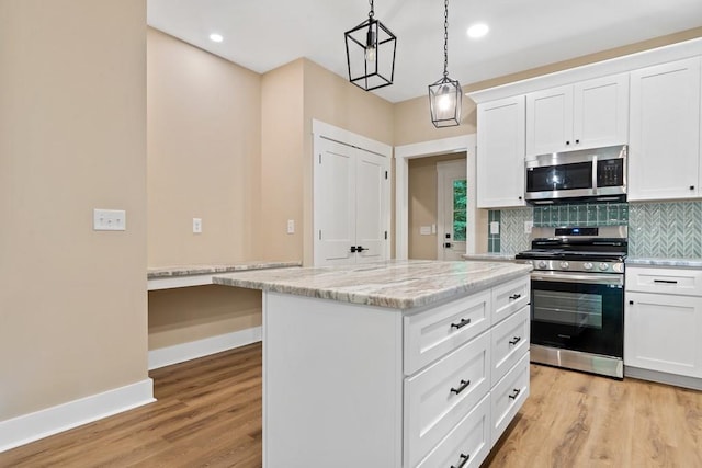 172 Southshore Rd, Eatonton, GA 31024 - kitchen featuring stainless steel appliances, light wood-style floors, tasteful backsplash, a kitchen island, and white cabinetry