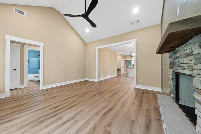 172 Southshore Rd, Eatonton, GA 31024 - unfurnished living room with ceiling fan, a stone fireplace, high vaulted ceiling, and light wood finished floors