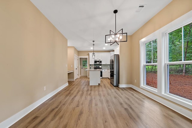 172 Southshore Rd, Eatonton, GA 31024 - kitchen featuring stainless steel appliances, light wood finished floors, white cabinetry, a chandelier, and light countertops