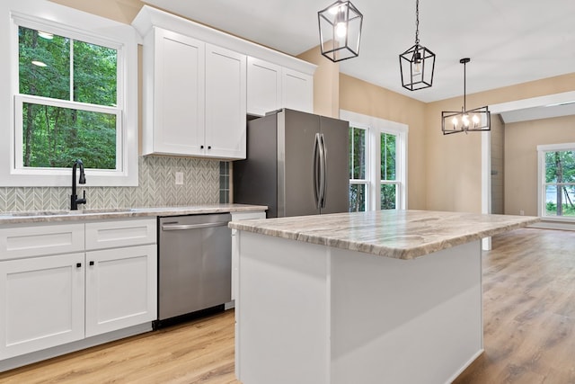 172 Southshore Rd, Eatonton, GA 31024 - kitchen featuring stainless steel appliances, decorative backsplash, white cabinets, light stone counters, and light wood-type flooring