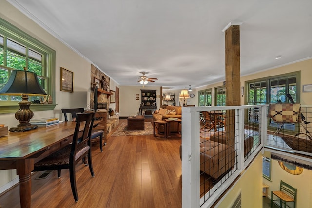 dining area with wood finished floors, ornamental molding, and a ceiling fan