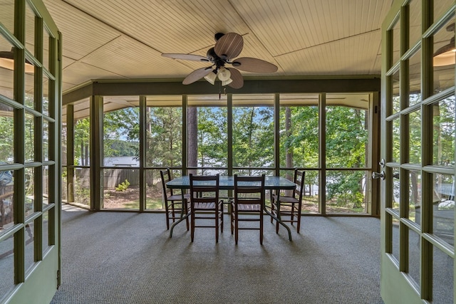 sunroom with ceiling fan, a water view, and outdoor dining area