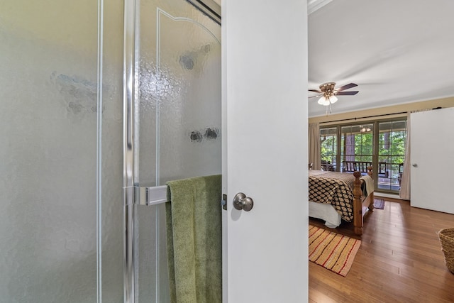 full bathroom with wood finished floors, a ceiling fan, and a shower stall