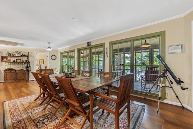 dining area featuring wood finished floors, ornamental molding, baseboards, and french doors