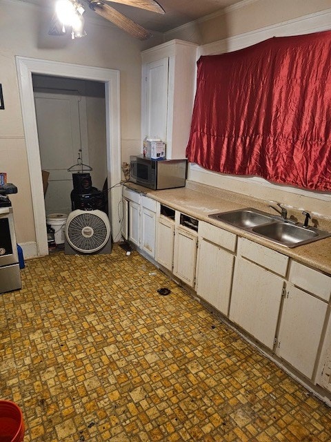 kitchen featuring white cabinetry, stainless steel electric range oven, sink, and ceiling fan