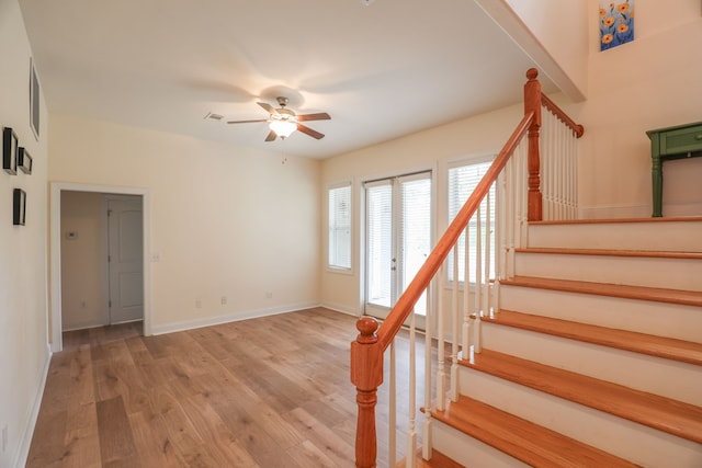 stairway with hardwood / wood-style flooring and ceiling fan